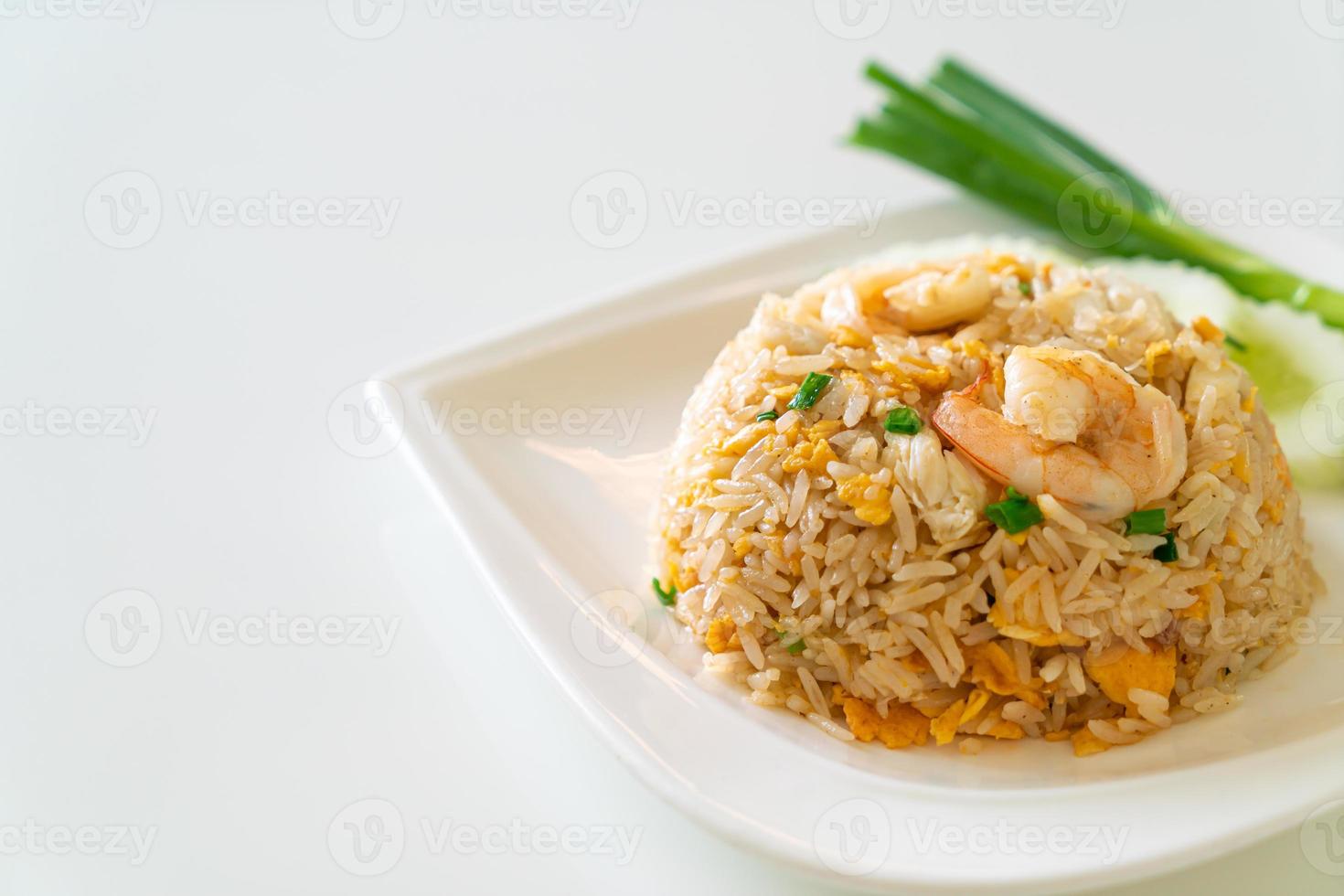 arroz frito com camarão e caranguejo no prato branco foto