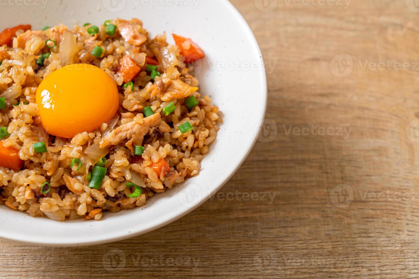 arroz frito de salmão com ovo em conserva por cima - comida asiática foto