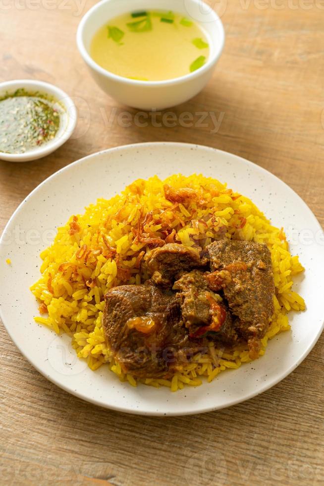 biryani de carne ou arroz com curry e carne - versão tailandês-muçulmana do biryani indiano, com arroz amarelo perfumado e carne bovina foto