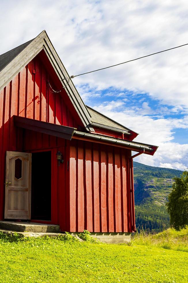 bela cabana de madeira vermelha cabana na colina na natureza da Noruega. foto