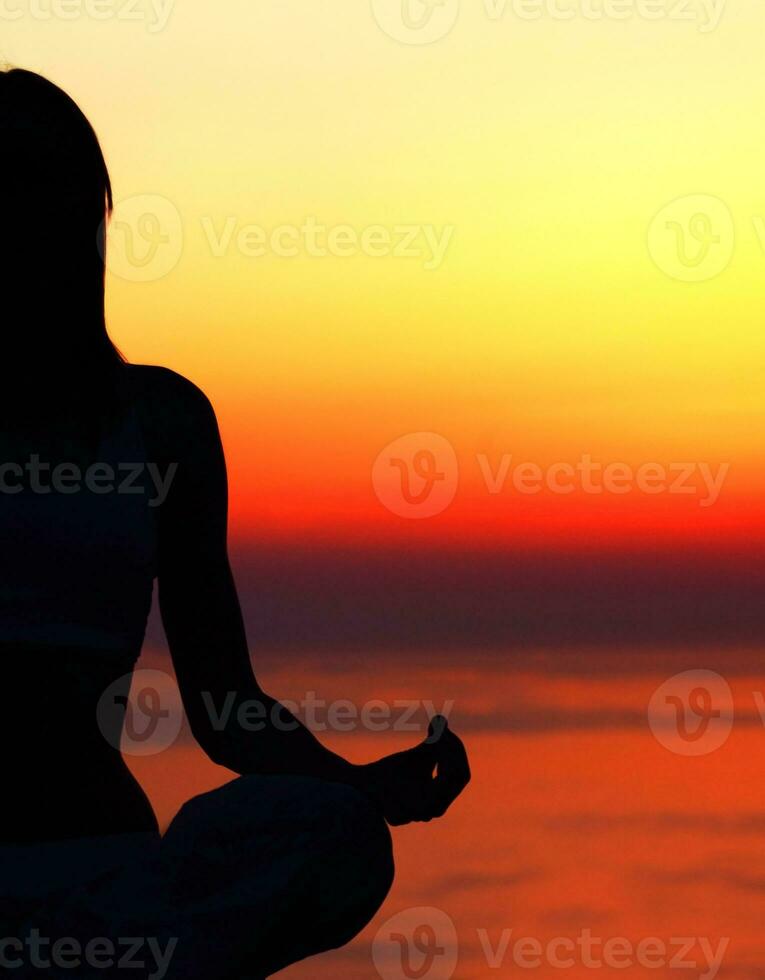 ioga mulher sobre pôr do sol foto