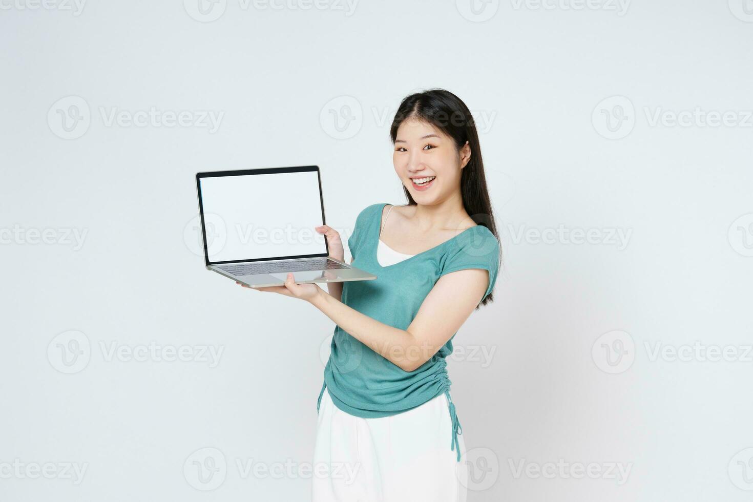 sorridente mulher mostrando em branco computador portátil computador tela isolado sobre branco fundo. foto