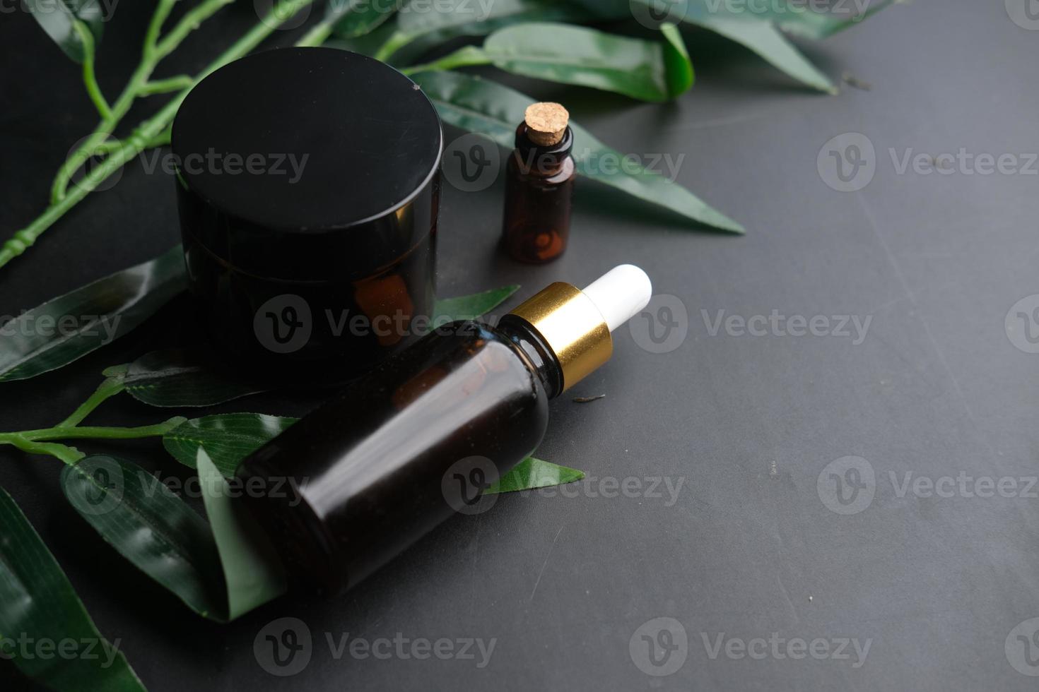 óleos essenciais de eucalipto em um frasco de vidro com folha verde na mesa preta foto