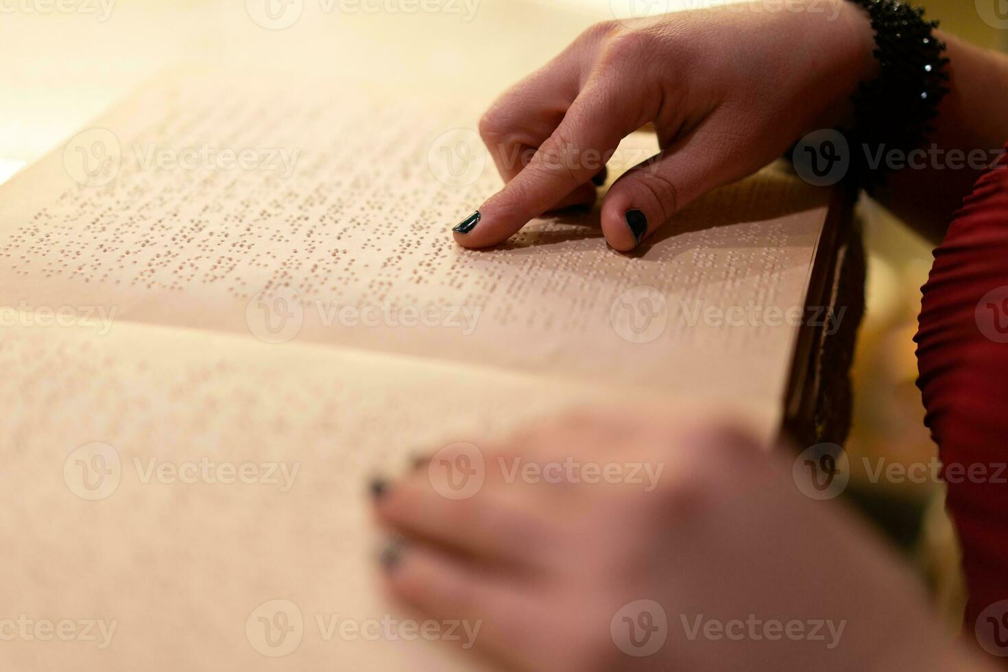 fechar-se do uma mulher mão lendo uma braille livro foto