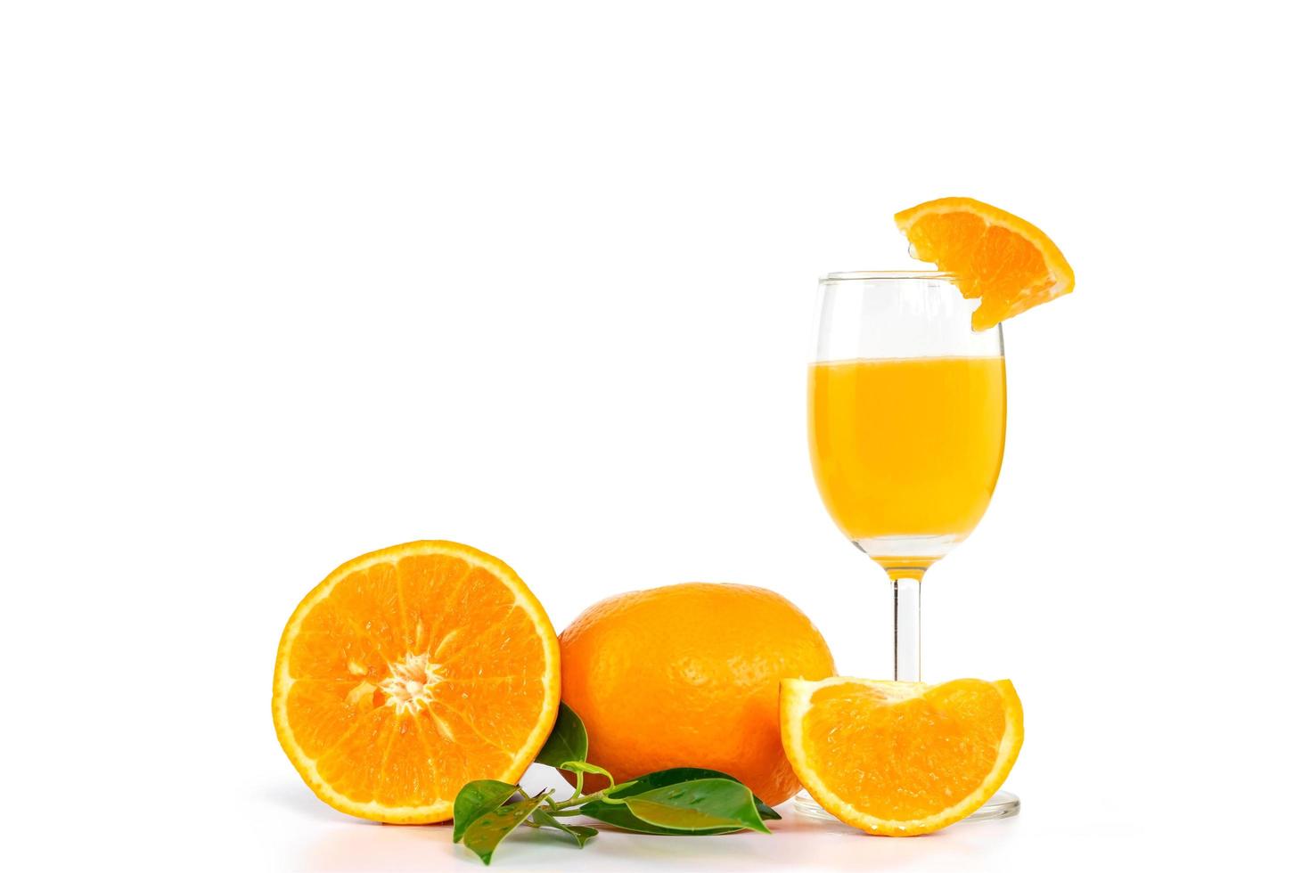 suco de laranja espremido na hora em um copo, decorado com frutas cítricas e folhas de laranja foto