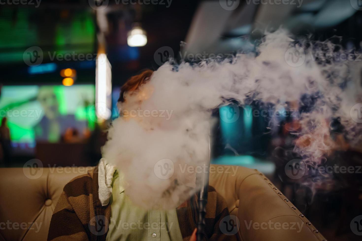 homem no restaurante fumando cachimbo de água. foto