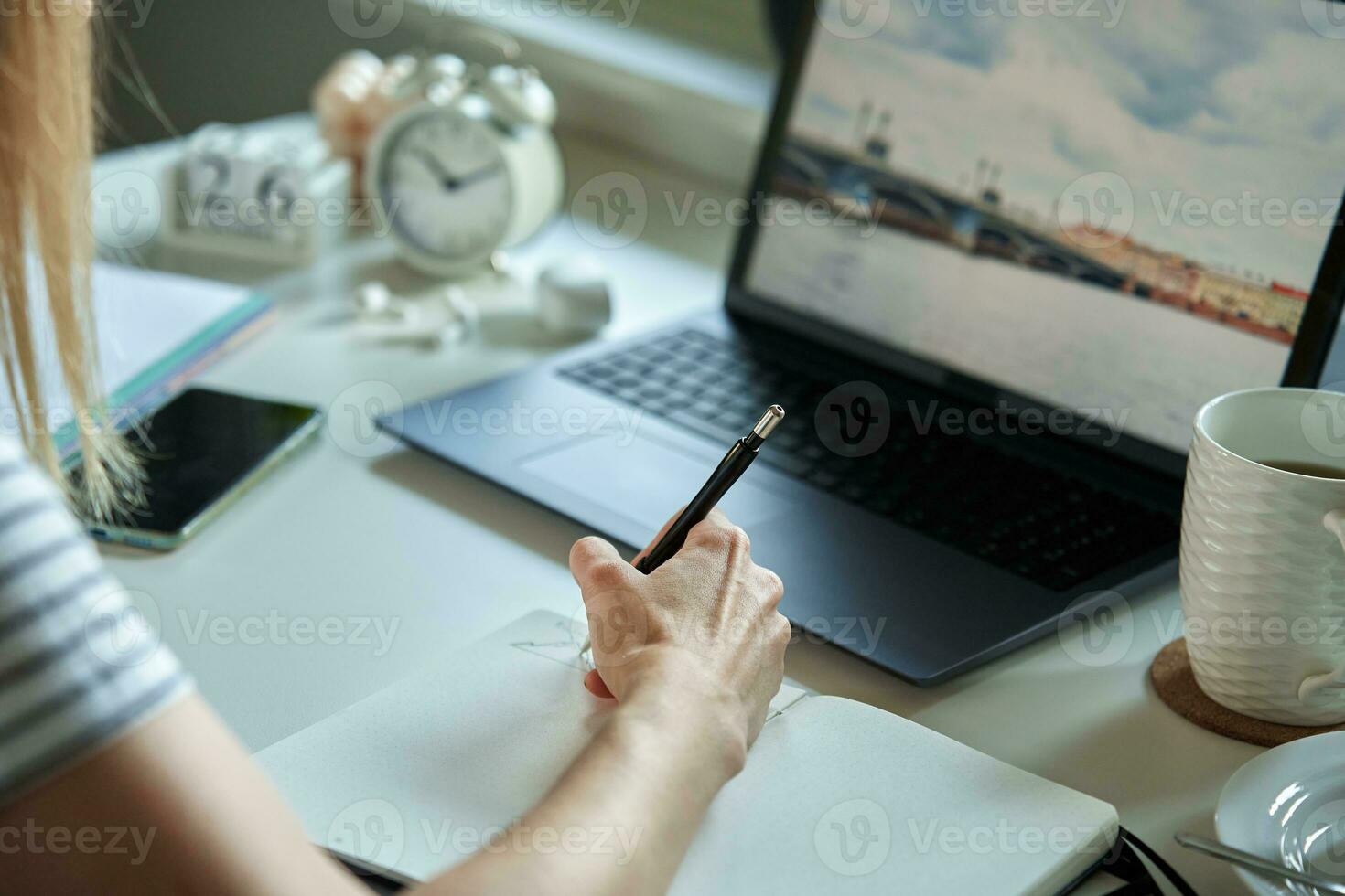 mulher sentado às mesa de a janela e usando computador portátil foto