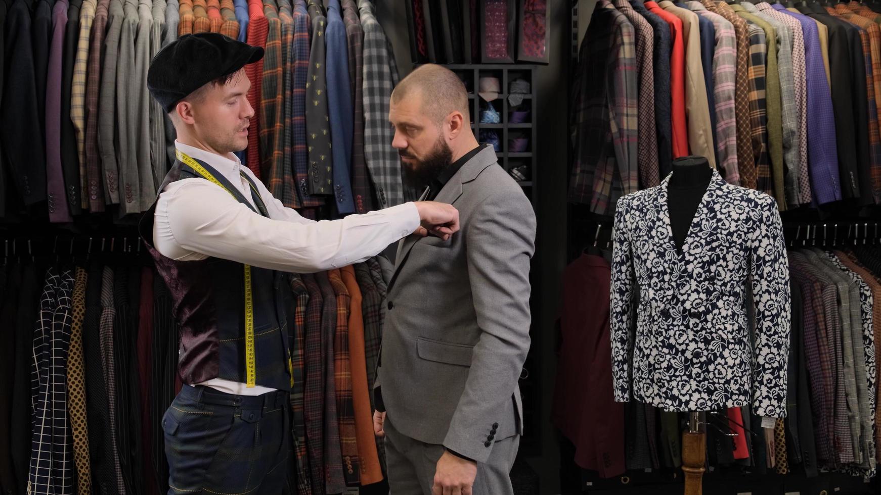 o estilista alfaiate medindo o terno com uma fita métrica no modelo masculino foto