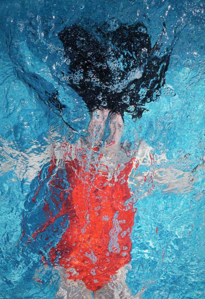 mulher mergulha na água. fundo desfocado abstrato. foto