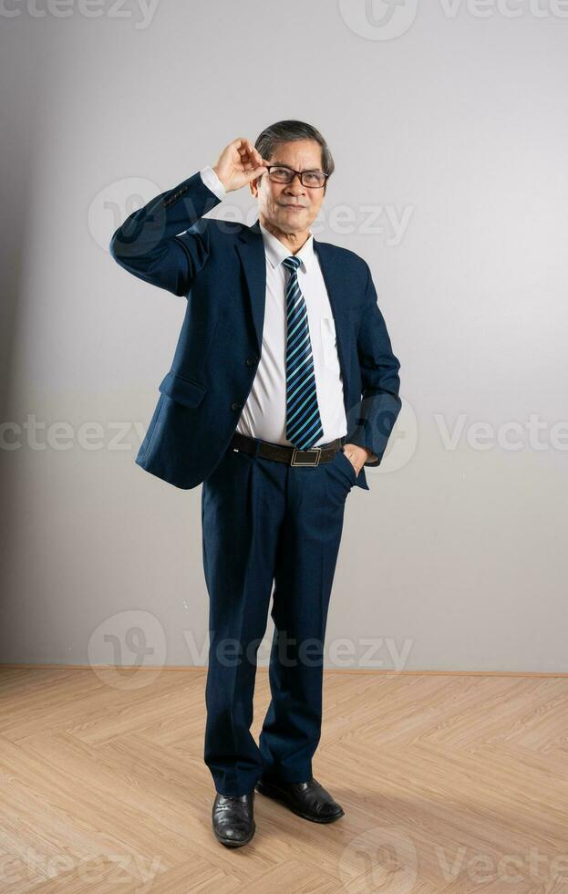 retrato do a idosos ásia homem de negocios, posando em uma azul fundo foto