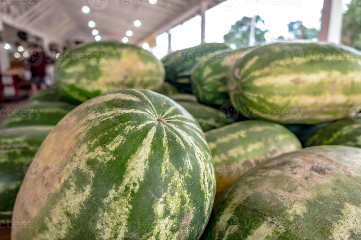 pilha de melancias frescas em caixas de madeira com frutas foto