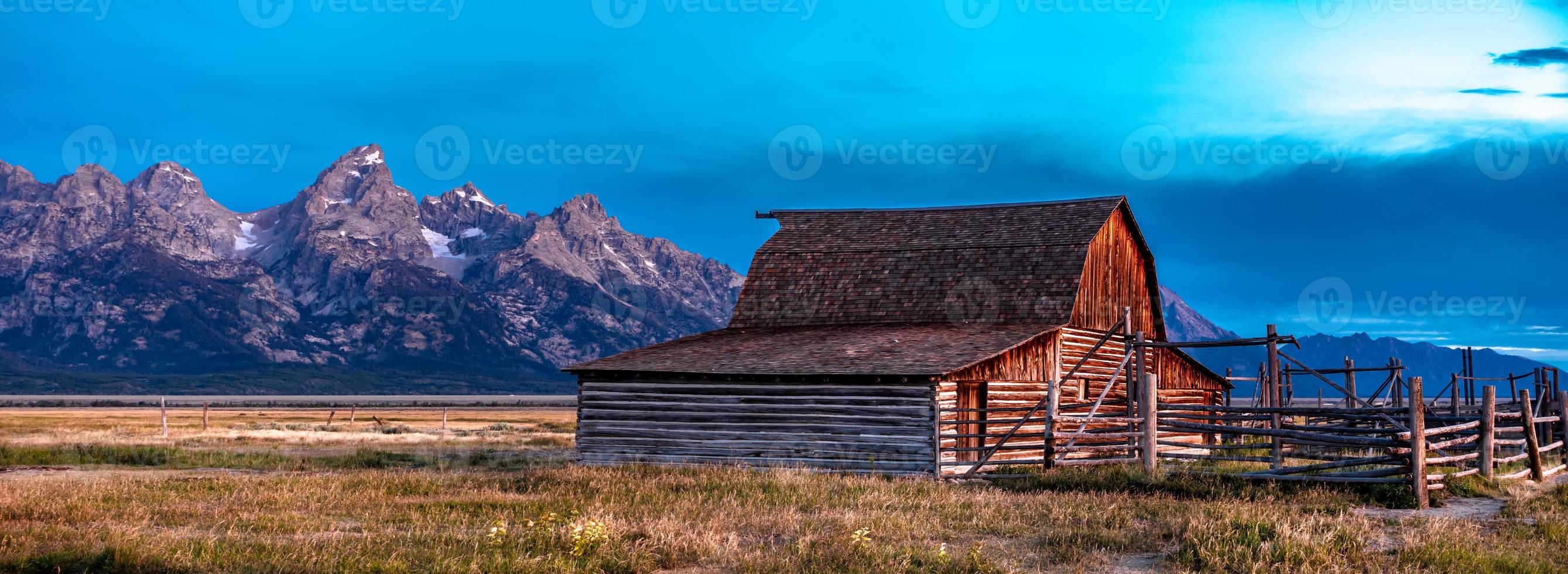 vista panorâmica do grand teton com celeiro abandonado na mormon row foto