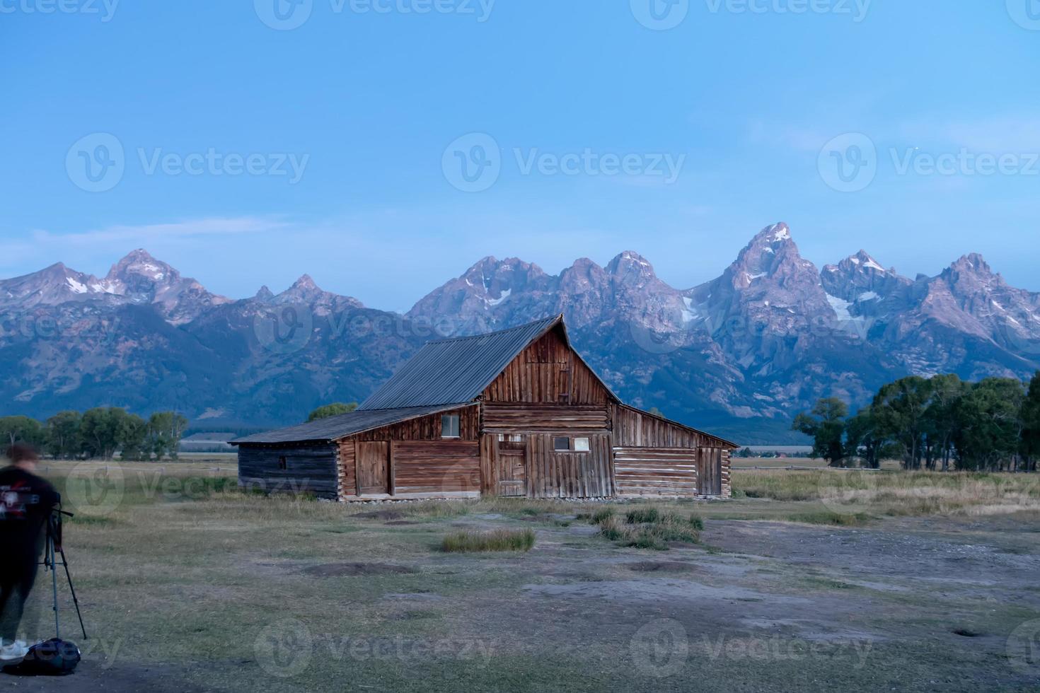 vista panorâmica do grand teton com celeiro abandonado na mormon row foto