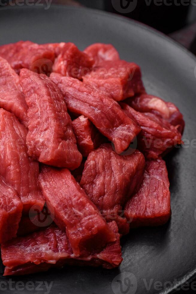 cru orgânico carne carne ou Cordeiro cortar para dentro fatias com sal, especiarias e ervas foto