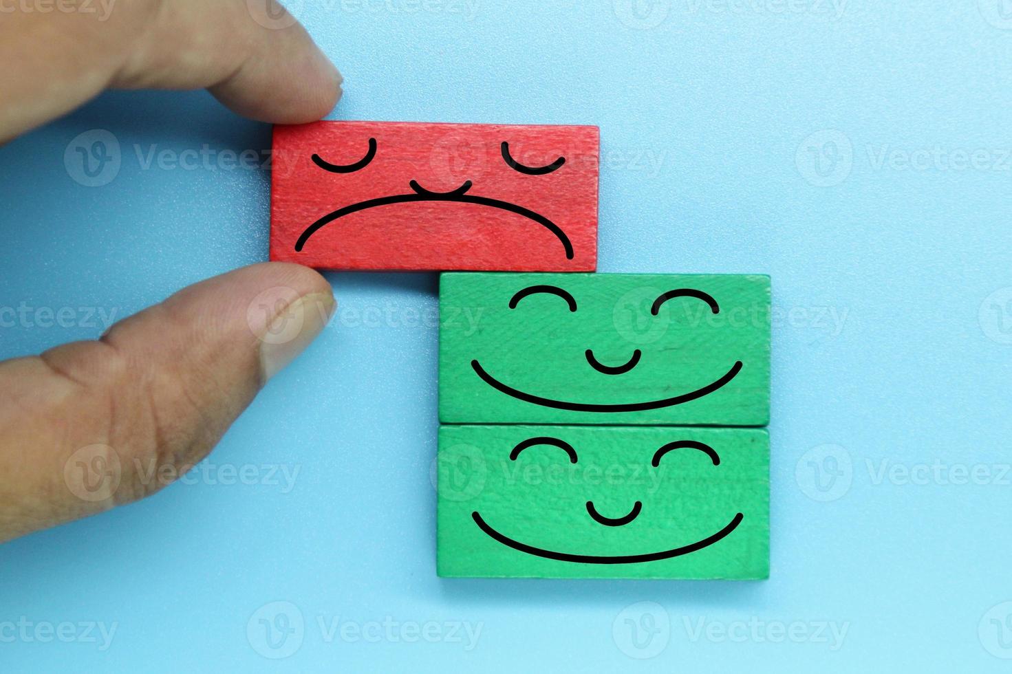 blocos de madeira coloridos com rosto de emoção. avaliação do cliente e conceito de satisfação. foto