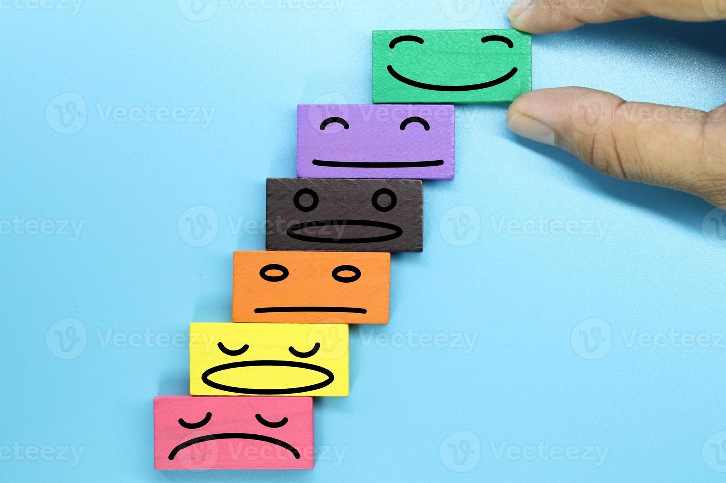 blocos de madeira coloridos com rosto de emoção. avaliação do cliente e conceito de satisfação. foto