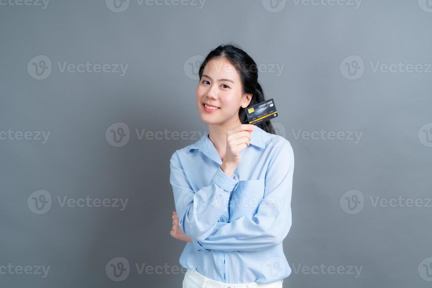 retrato de uma adorável jovem asiática mostrando cartão de crédito foto