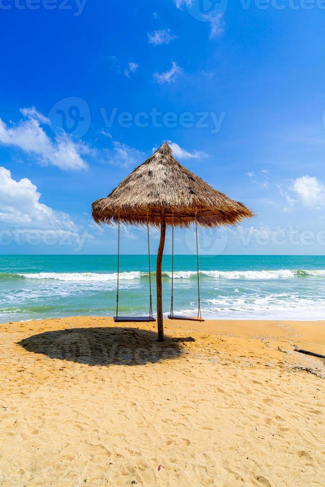 balançar na praia com o oceano, o mar e o fundo do céu azul foto