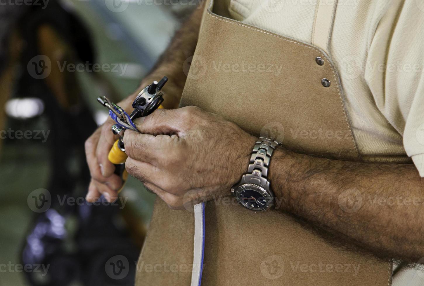 fazendo furos em um pedaço de couro foto