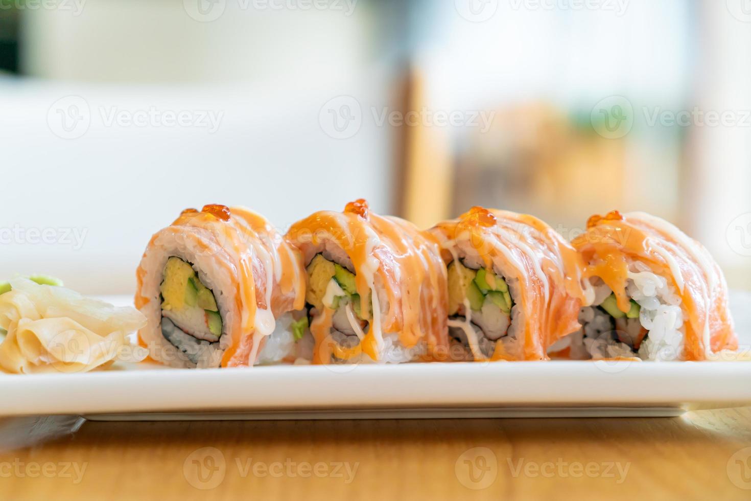 Sushi roll de salmão com molho por cima - comida japonesa foto