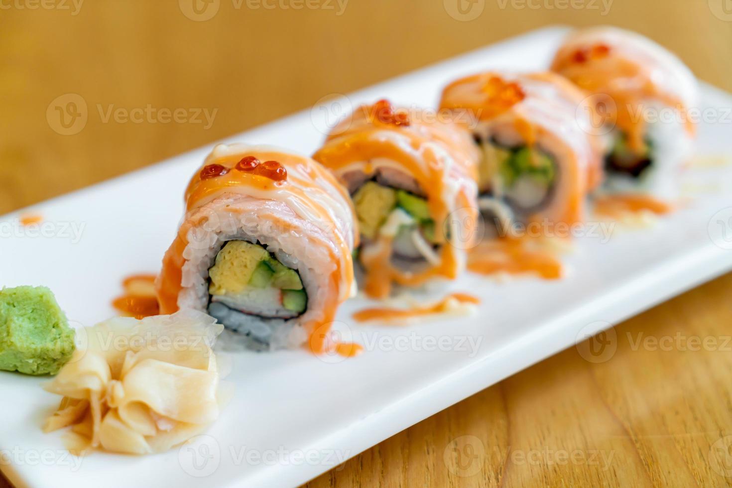Sushi roll de salmão com molho por cima - comida japonesa foto