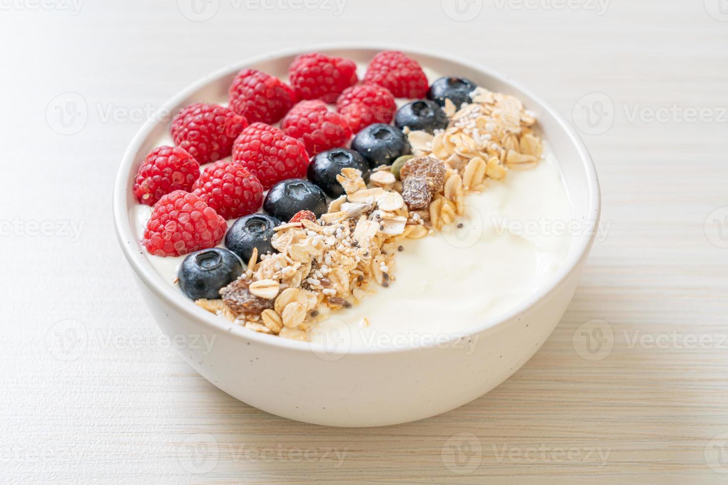 tigela de iogurte caseiro com framboesa, mirtilo e granola - estilo de comida saudável foto