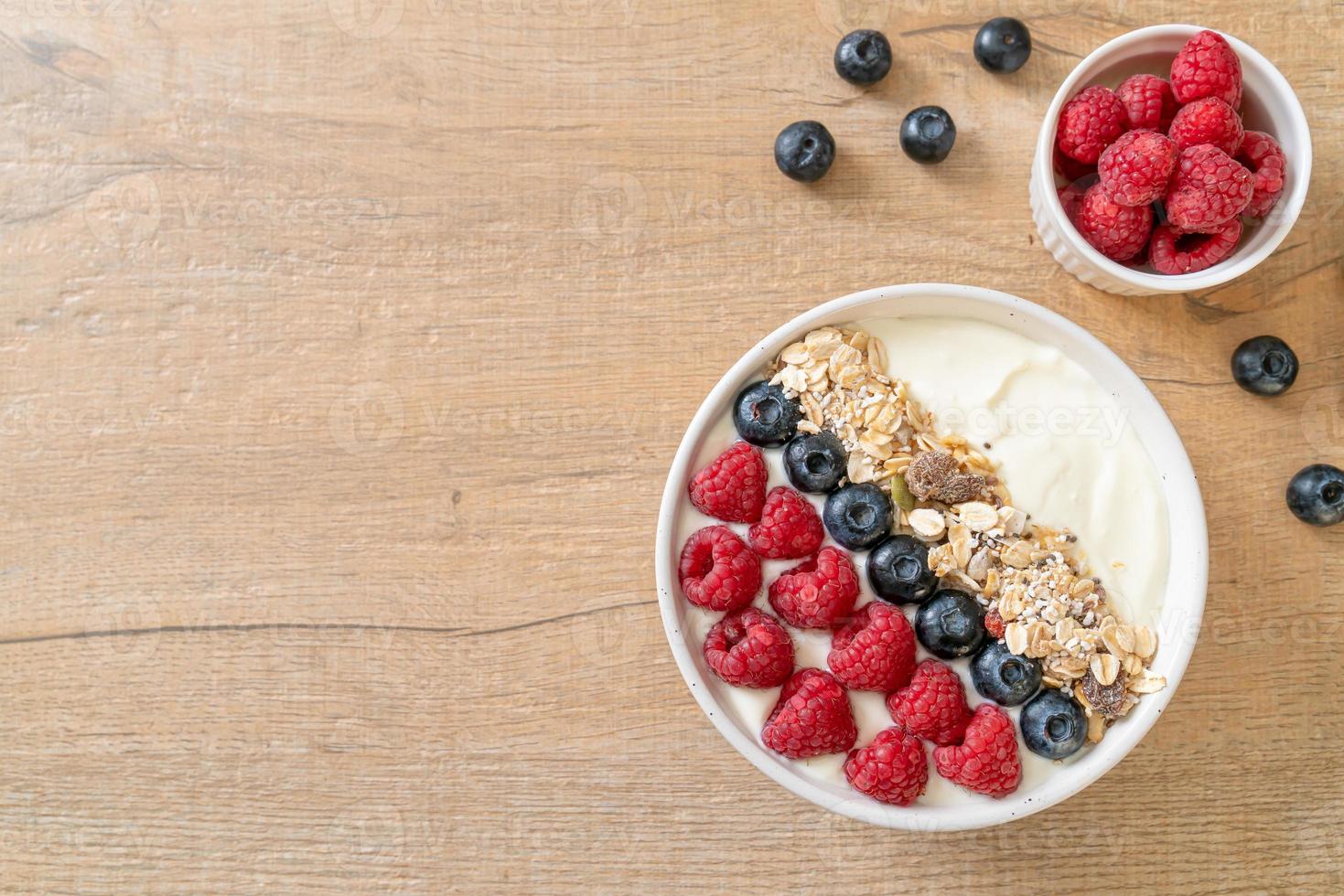 tigela de iogurte caseiro com framboesa, mirtilo e granola - estilo de comida saudável foto