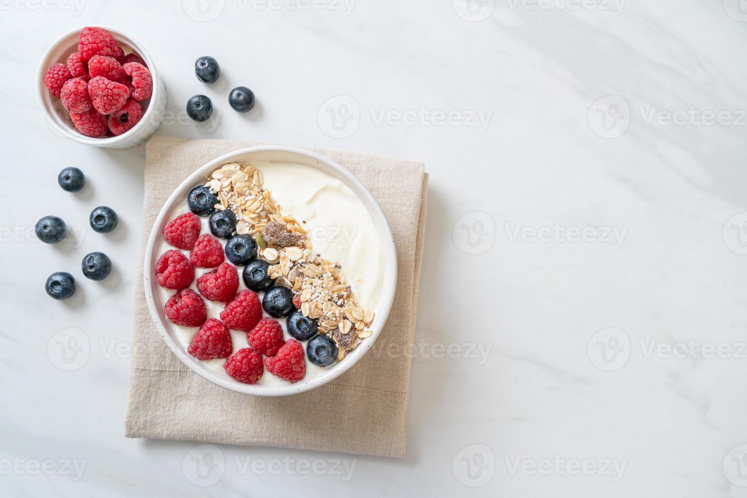 tigela de iogurte caseiro com framboesa, mirtilo e granola - estilo de comida saudável foto