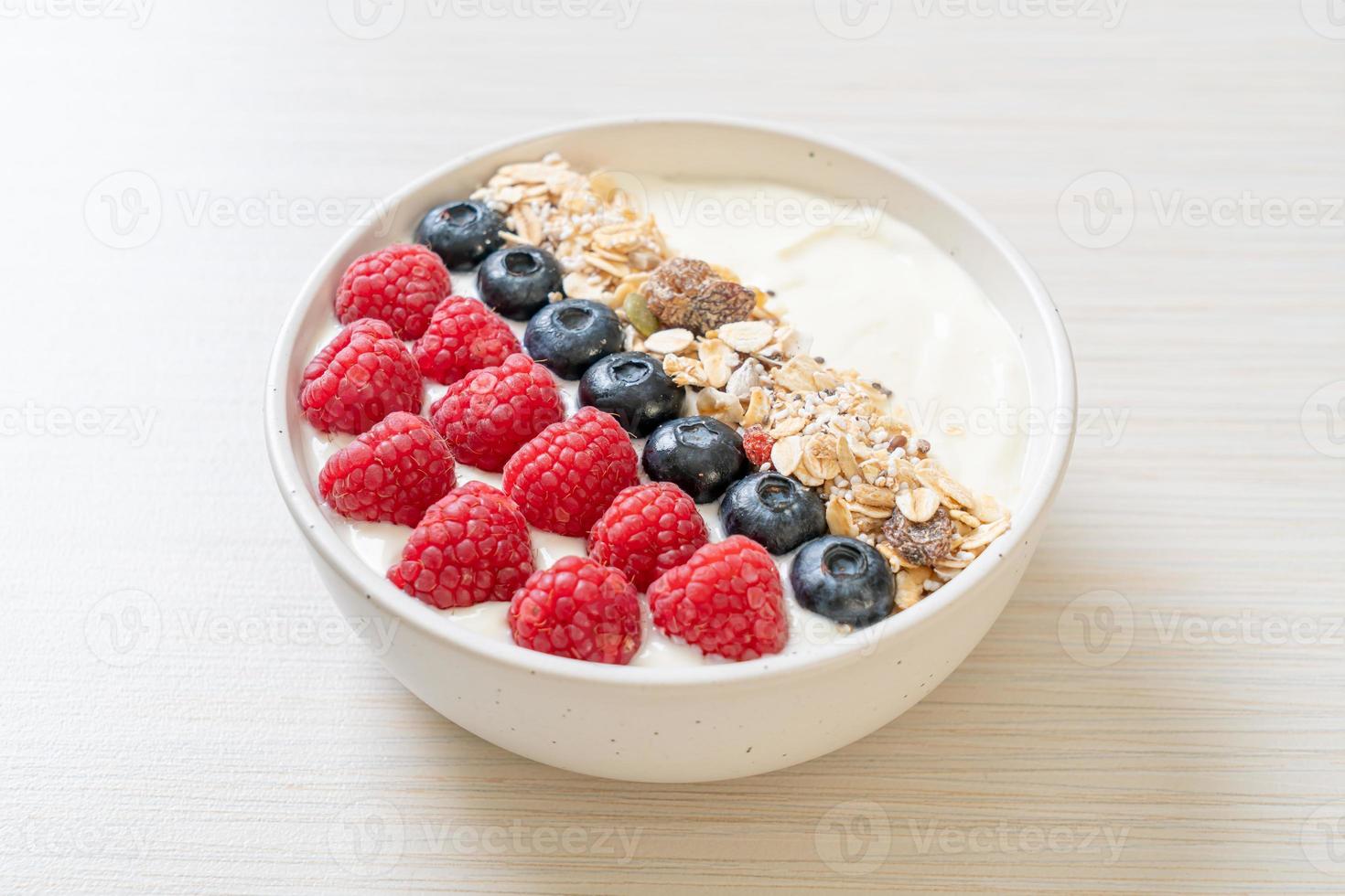 tigela de iogurte caseiro com framboesa, mirtilo e granola - estilo de comida saudável foto