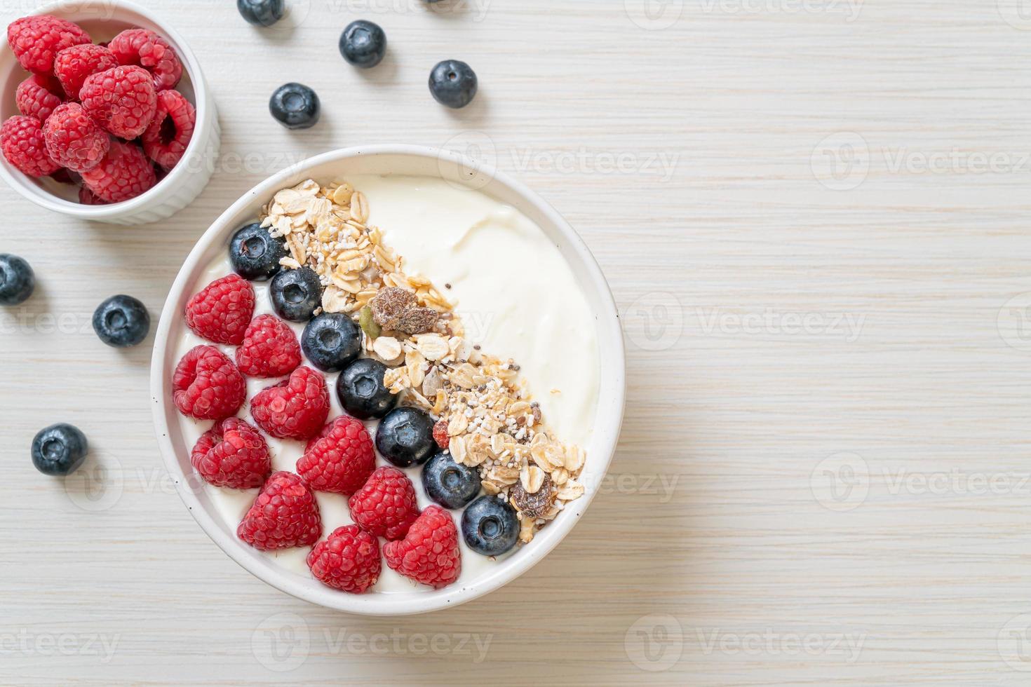 tigela de iogurte caseiro com framboesa, mirtilo e granola - estilo de comida saudável foto