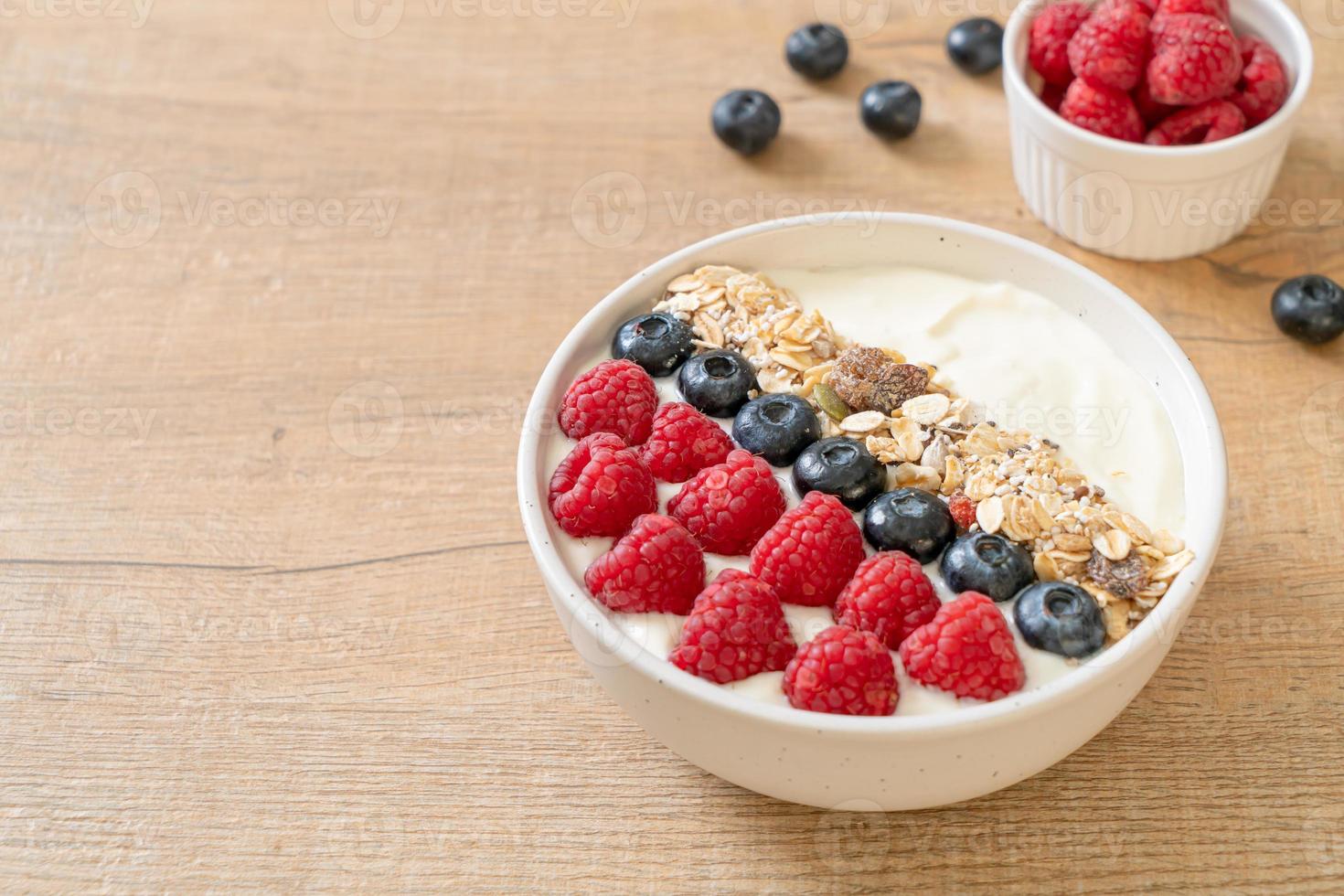 tigela de iogurte caseiro com framboesa, mirtilo e granola - estilo de comida saudável foto