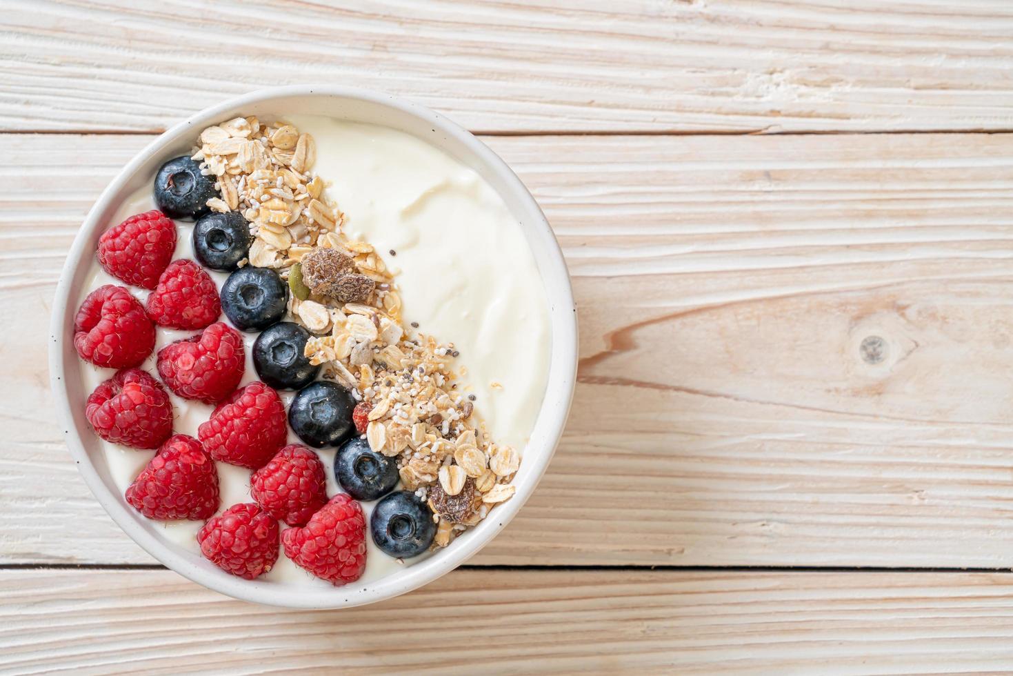 tigela de iogurte caseiro com framboesa, mirtilo e granola - estilo de comida saudável foto