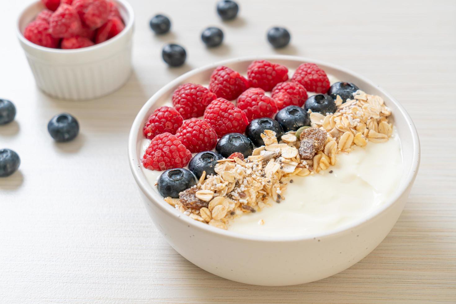 tigela de iogurte caseiro com framboesa, mirtilo e granola - estilo de comida saudável foto