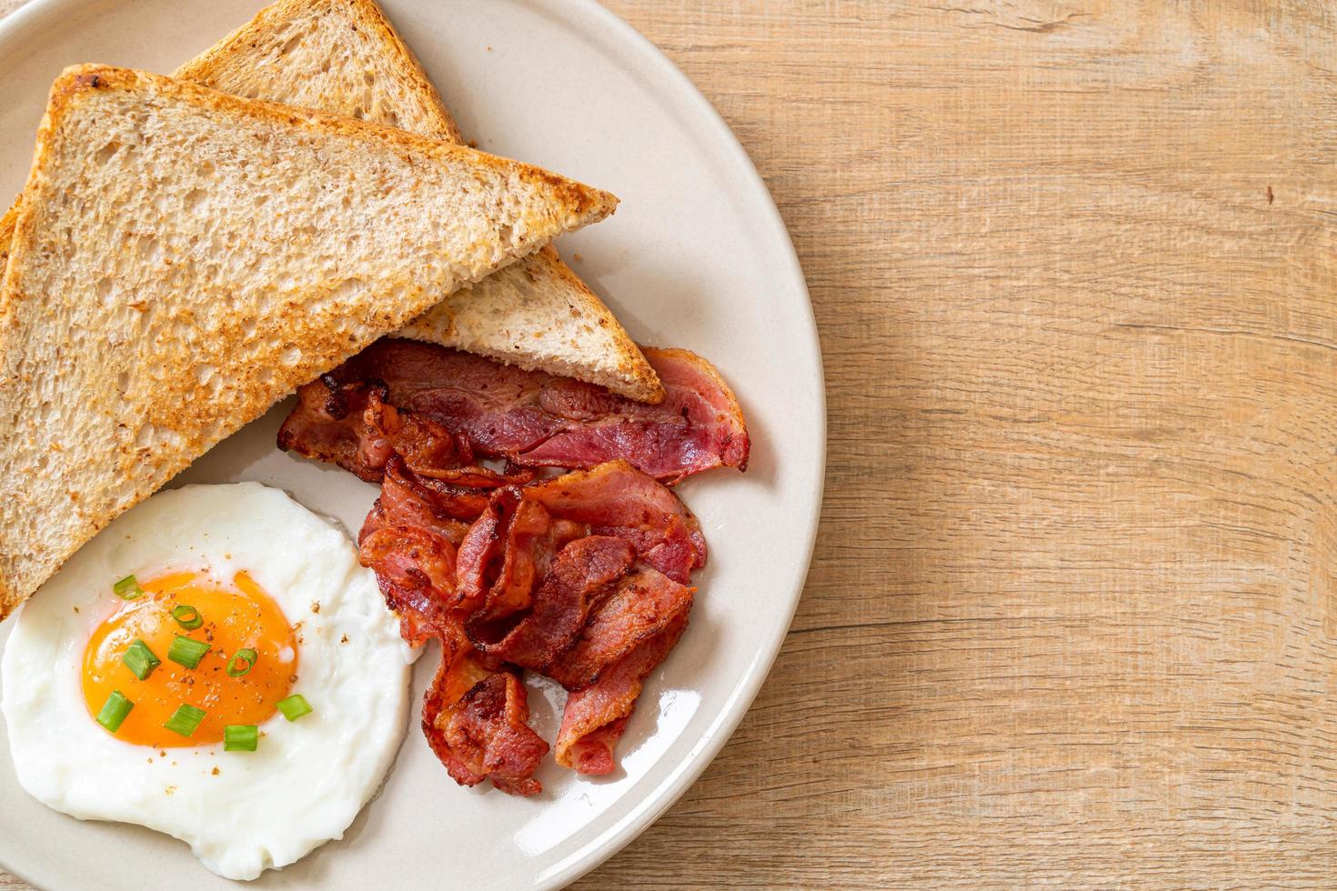 ovo frito com pão torrado e bacon no café da manhã foto