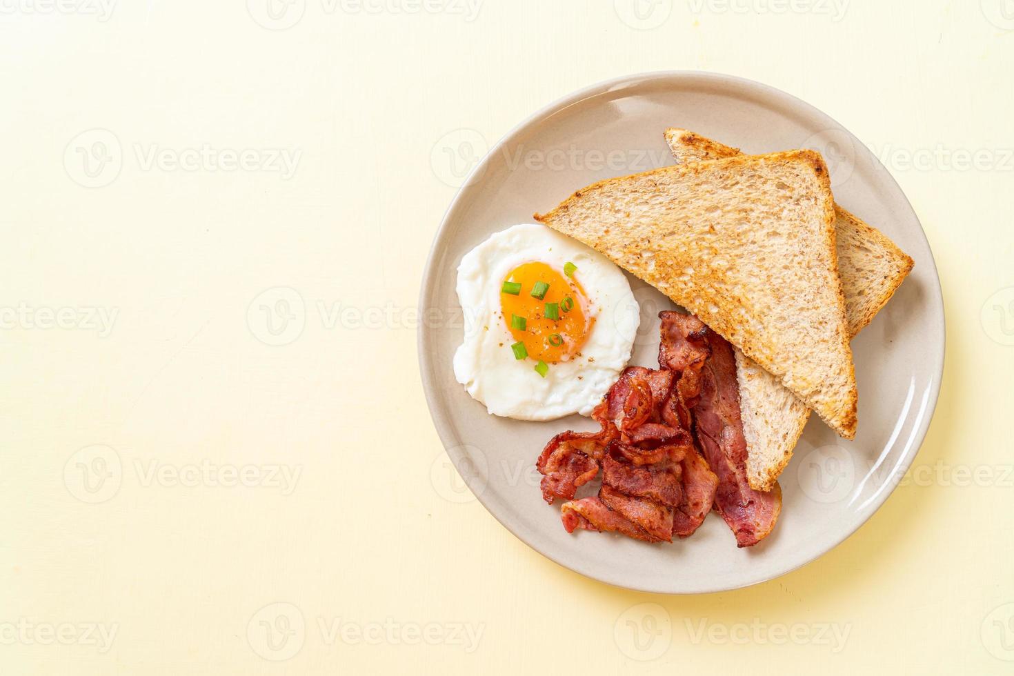 ovo frito com pão torrado e bacon no café da manhã foto