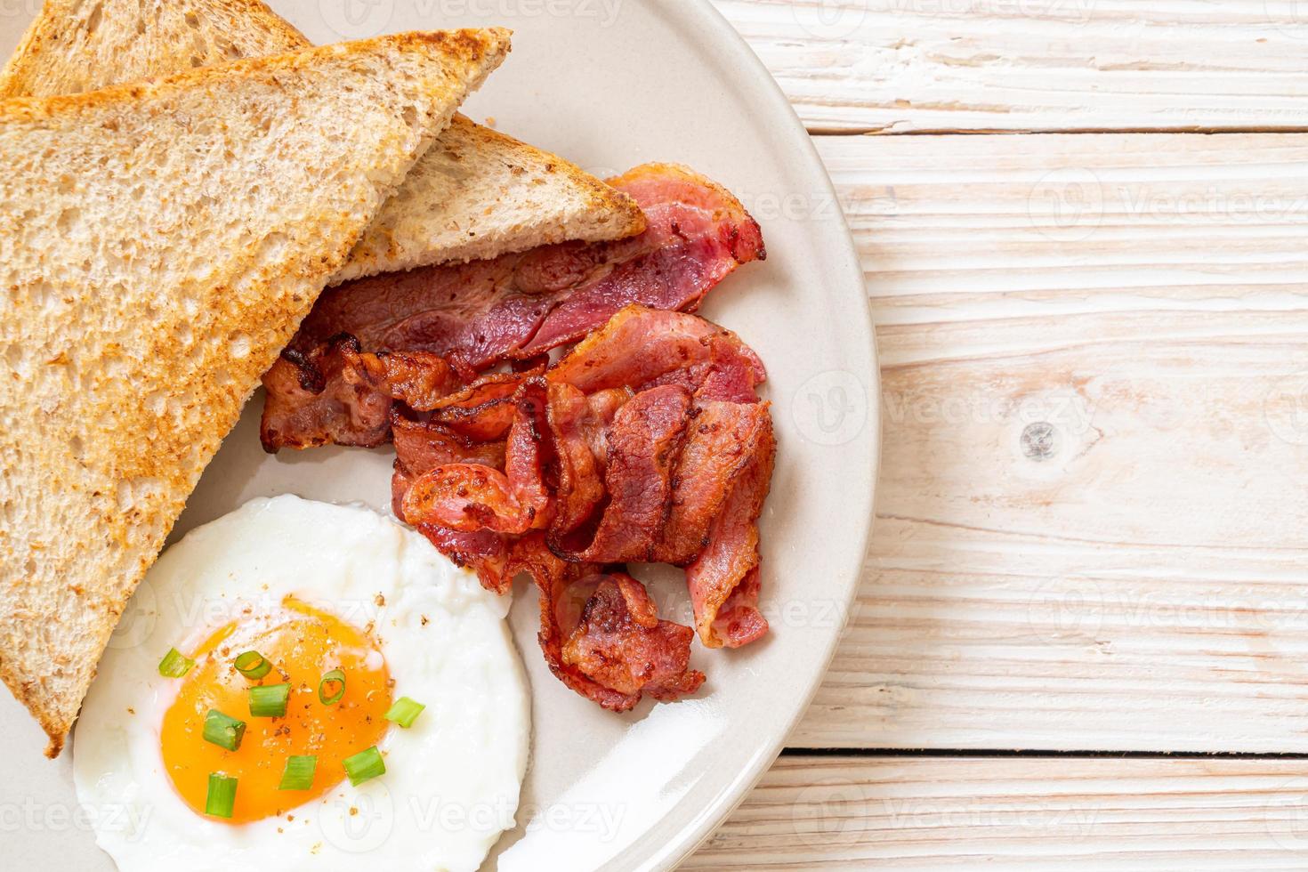 ovo frito com pão torrado e bacon no café da manhã foto