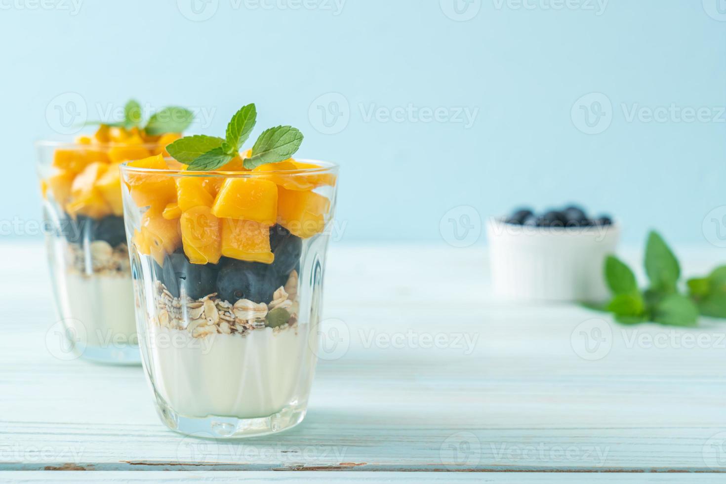 manga fresca caseira e mirtilo fresco com iogurte e granola - estilo de comida saudável foto