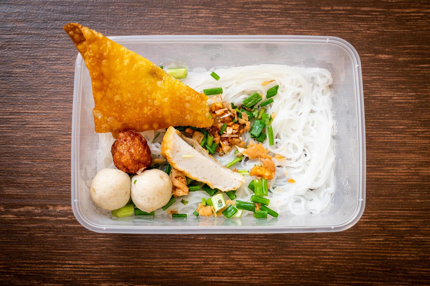 macarrão com bola de peixe e carne de porco picada na caixa de entrega - comida asiática foto