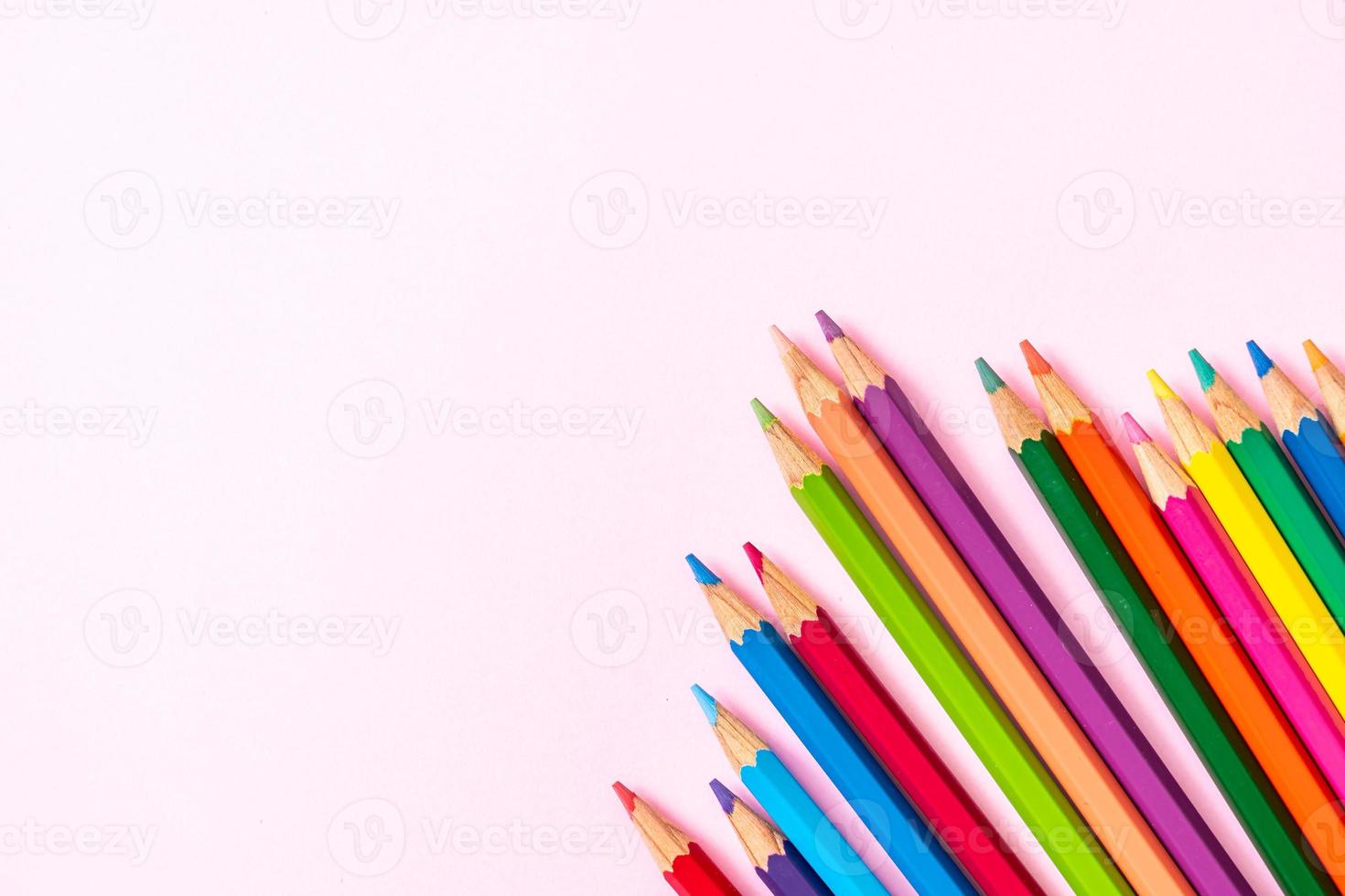 lápis de cor em fundo rosa com espaço de cópia foto