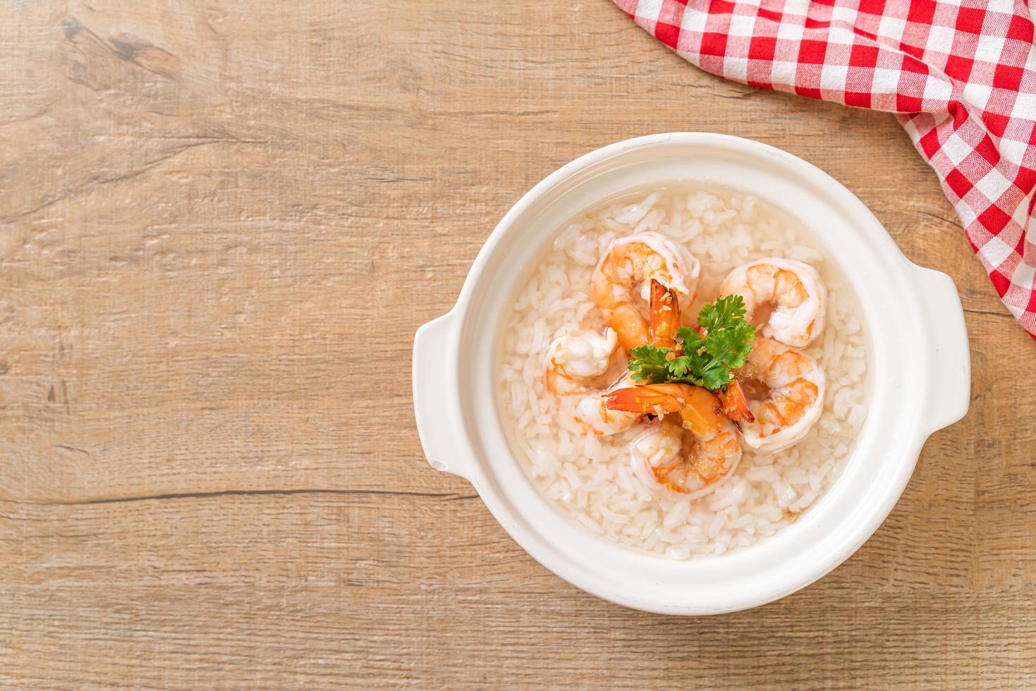 mingau ou sopa de arroz cozido com tigela de camarão foto