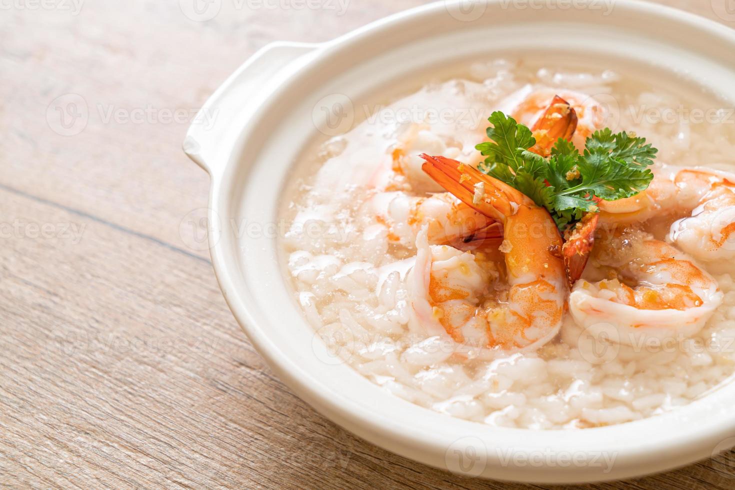 mingau ou sopa de arroz cozido com tigela de camarão foto