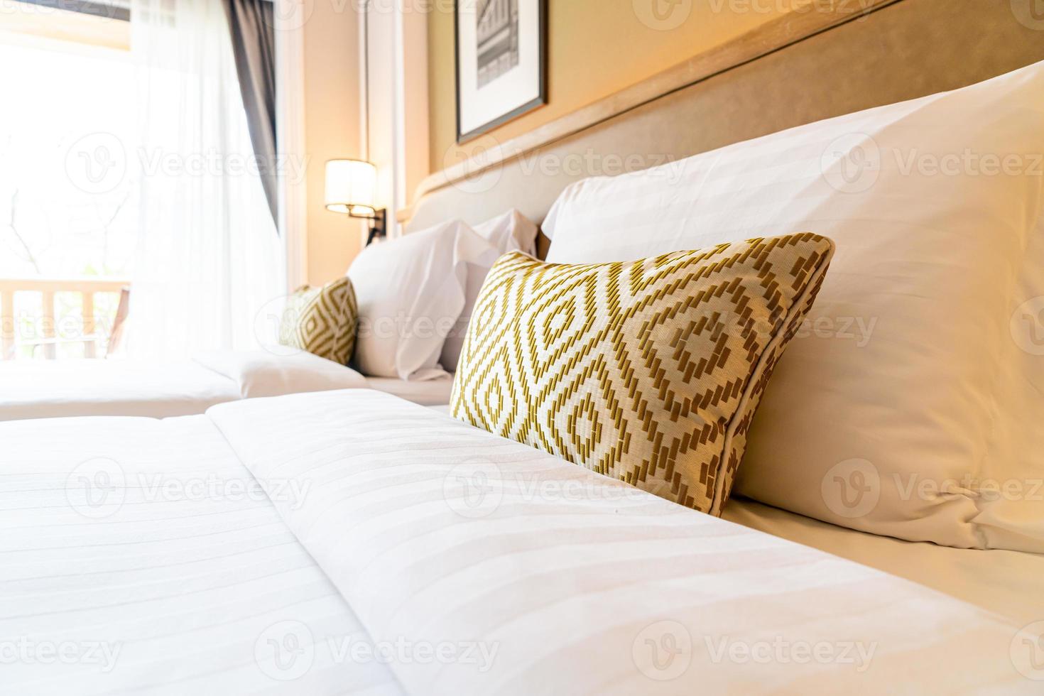 decoração de travesseiros confortáveis na cama do quarto do hotel foto