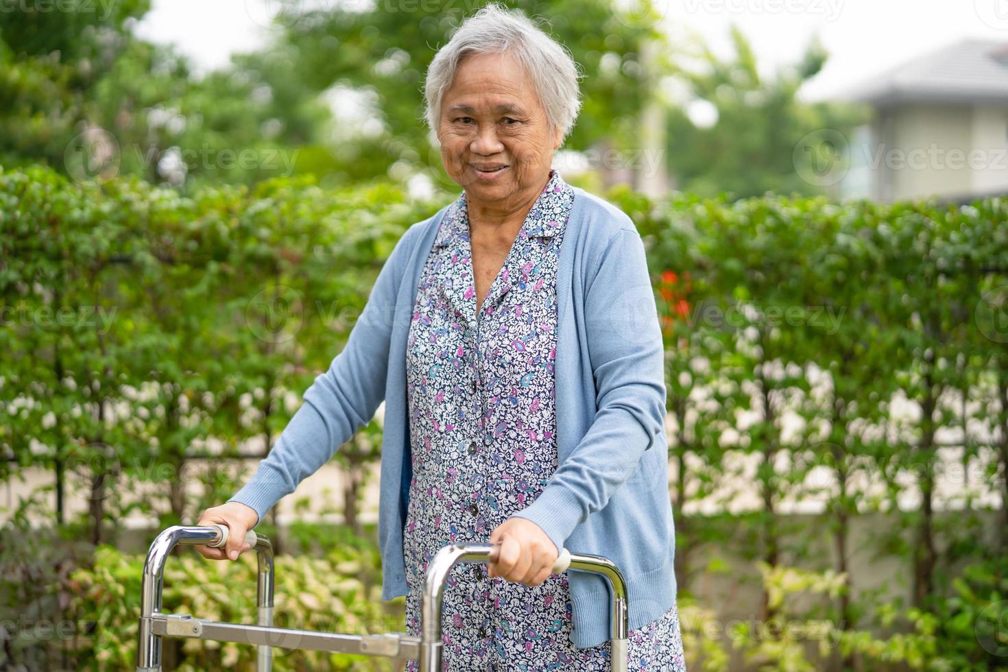 Mulher idosa idosa ou sênior asiática usa andador com saúde forte enquanto caminha no parque em um feriado feliz foto