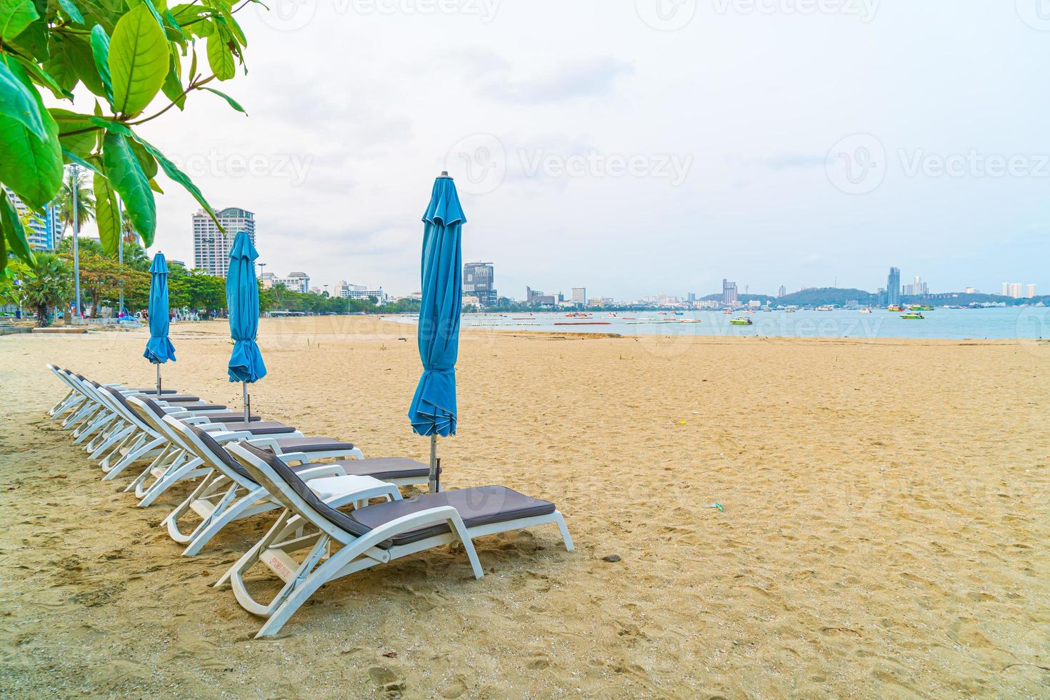 cadeiras de praia com guarda-sóis na praia marítima de Pattaya, na Tailândia foto