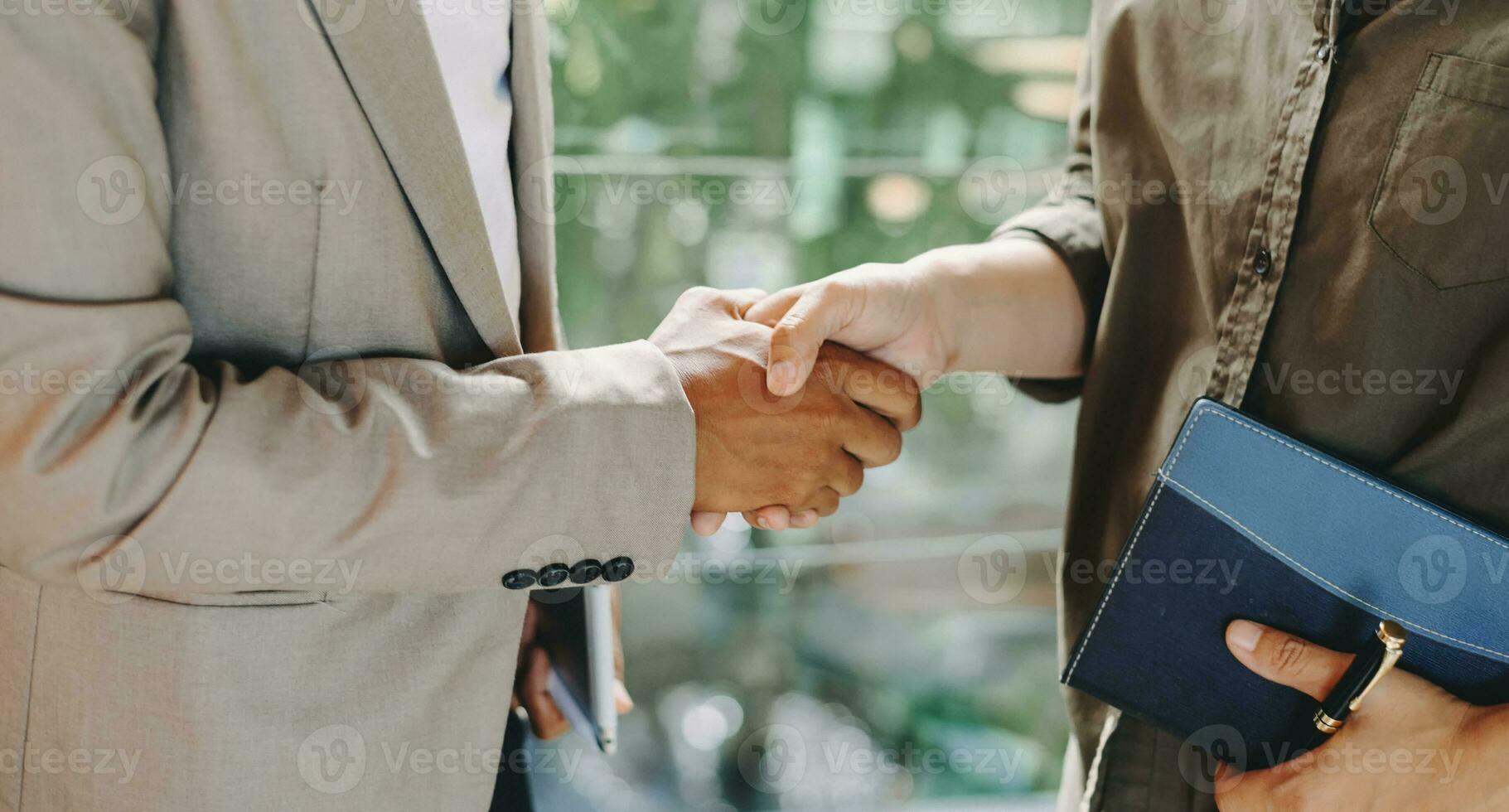 dois homem de negócios confiante apertando as mãos durante uma reunião no escritório, sucesso e parceiro foto