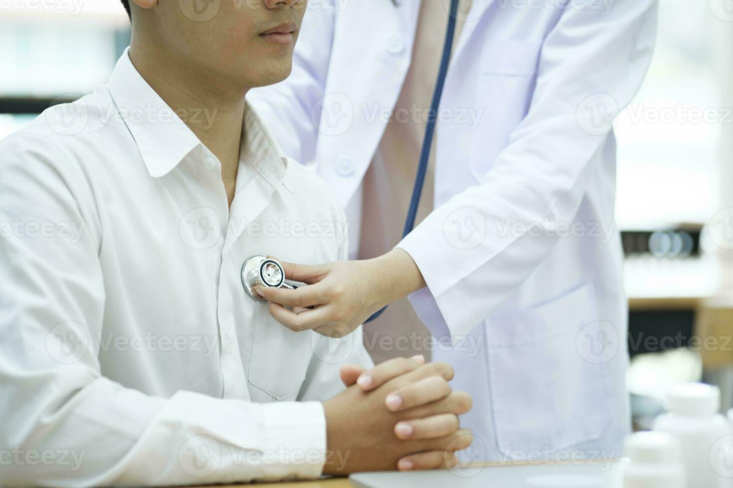 jovem médico é usando uma estetoscópio ouço para a batimento cardiaco do a paciente. foto