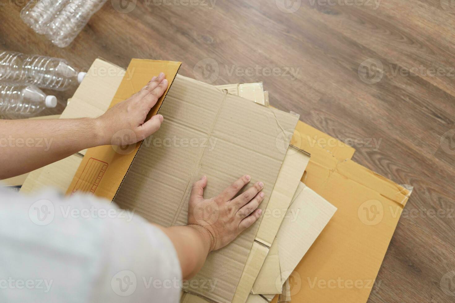 casa reciclar eco zero desperdício conceito homem usando reciclar papel caixa. empilhamento Castanho cartão caixa eco amigáveis embalagem fez do reciclável cru materiais. foto