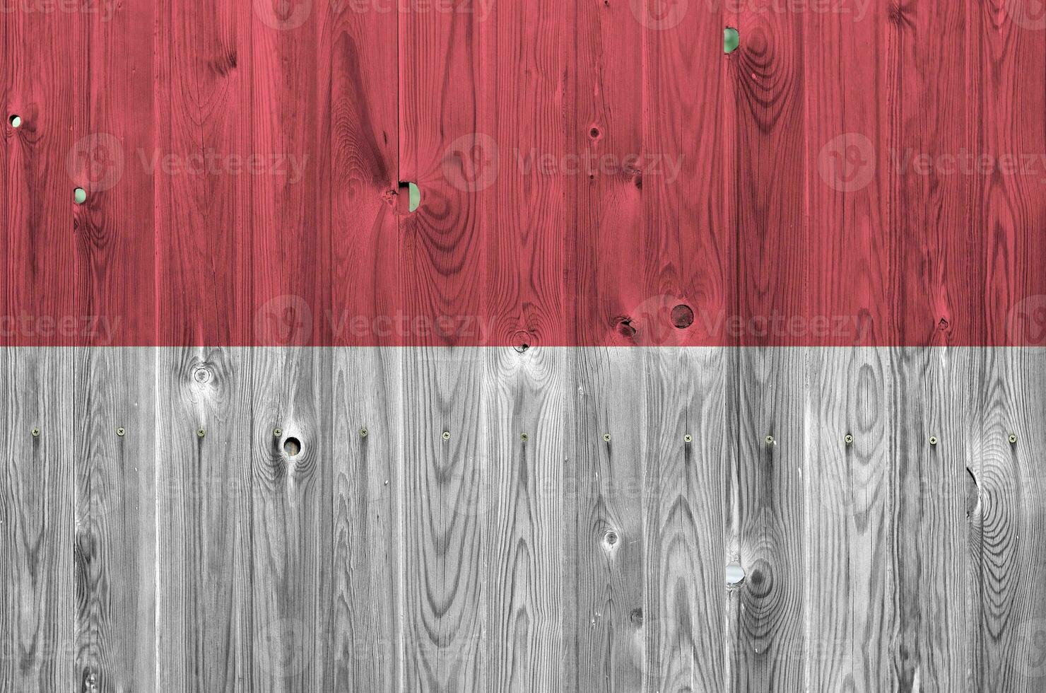 bandeira de mônaco retratada em cores de tinta brilhante na parede de madeira velha. banner texturizado em fundo áspero foto