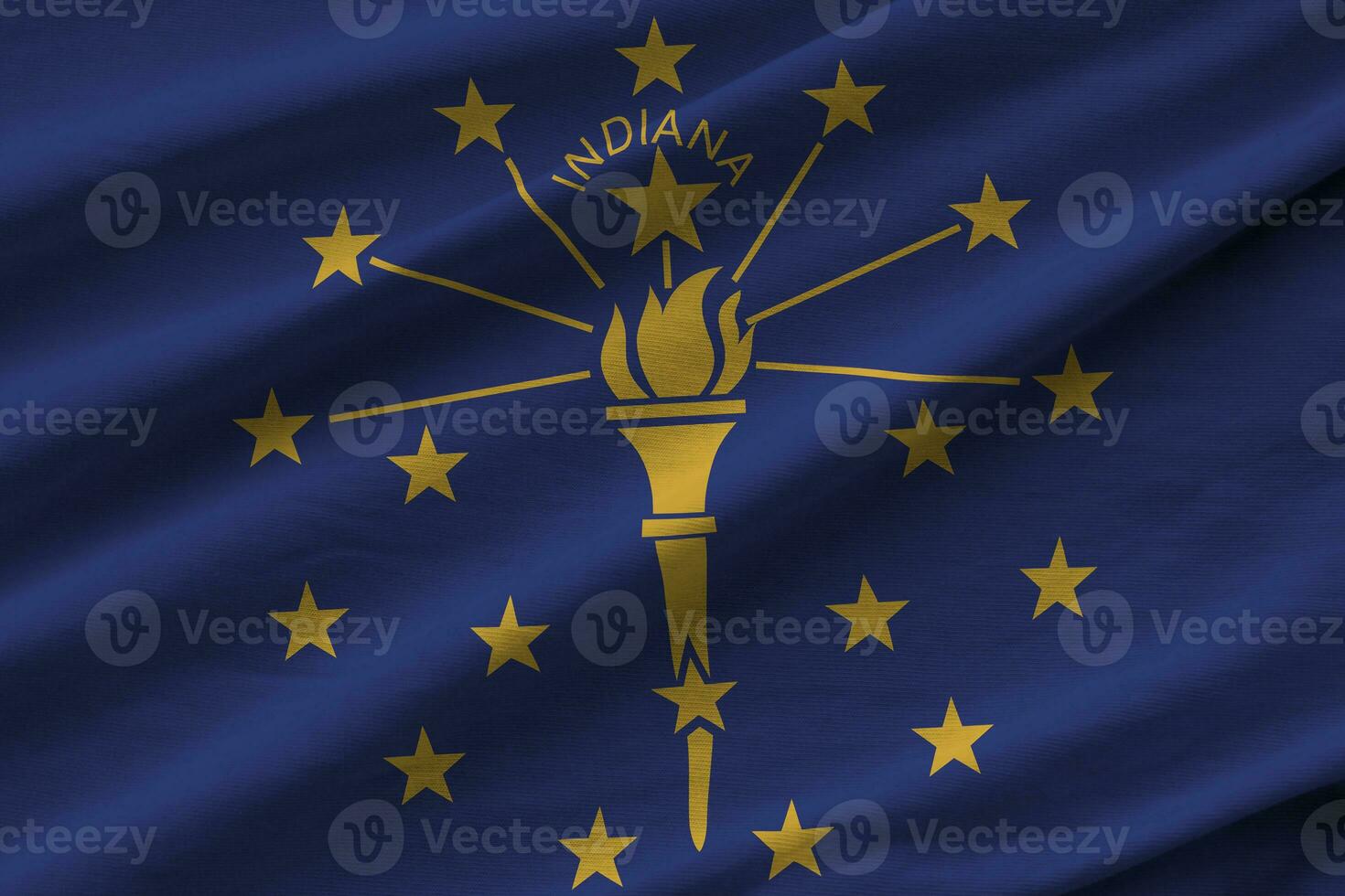 Indiana EUA bandeira do estado com grandes dobras acenando de perto sob a luz do estúdio dentro de casa. os símbolos oficiais e cores no banner foto