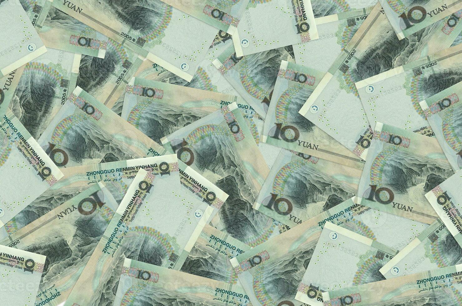 10 notas de yuan chinês estão em uma grande pilha. fundo conceitual de vida rica foto